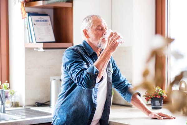 An old man drinking water