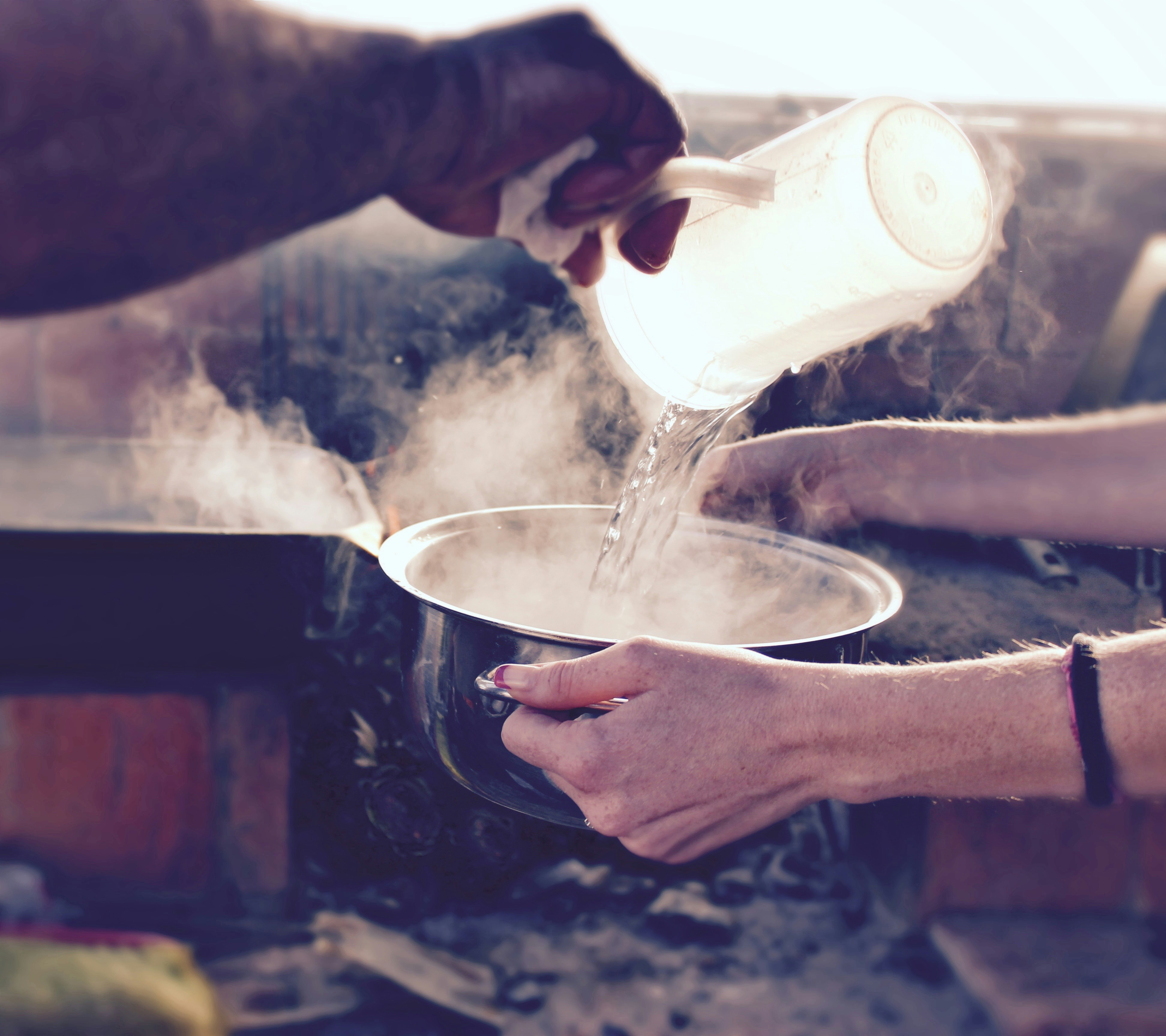 man pouring water into hot pot